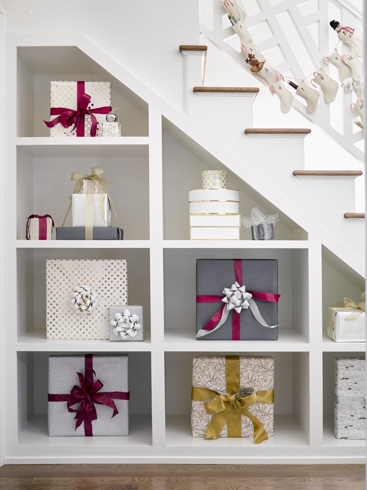 Jessica Bradley creatively fills an under the staircase shelving with pretty wrapped presents. This is off the cutest little girl's bedroom. Wait until you see it. This photo courtesy of David Christensen.
